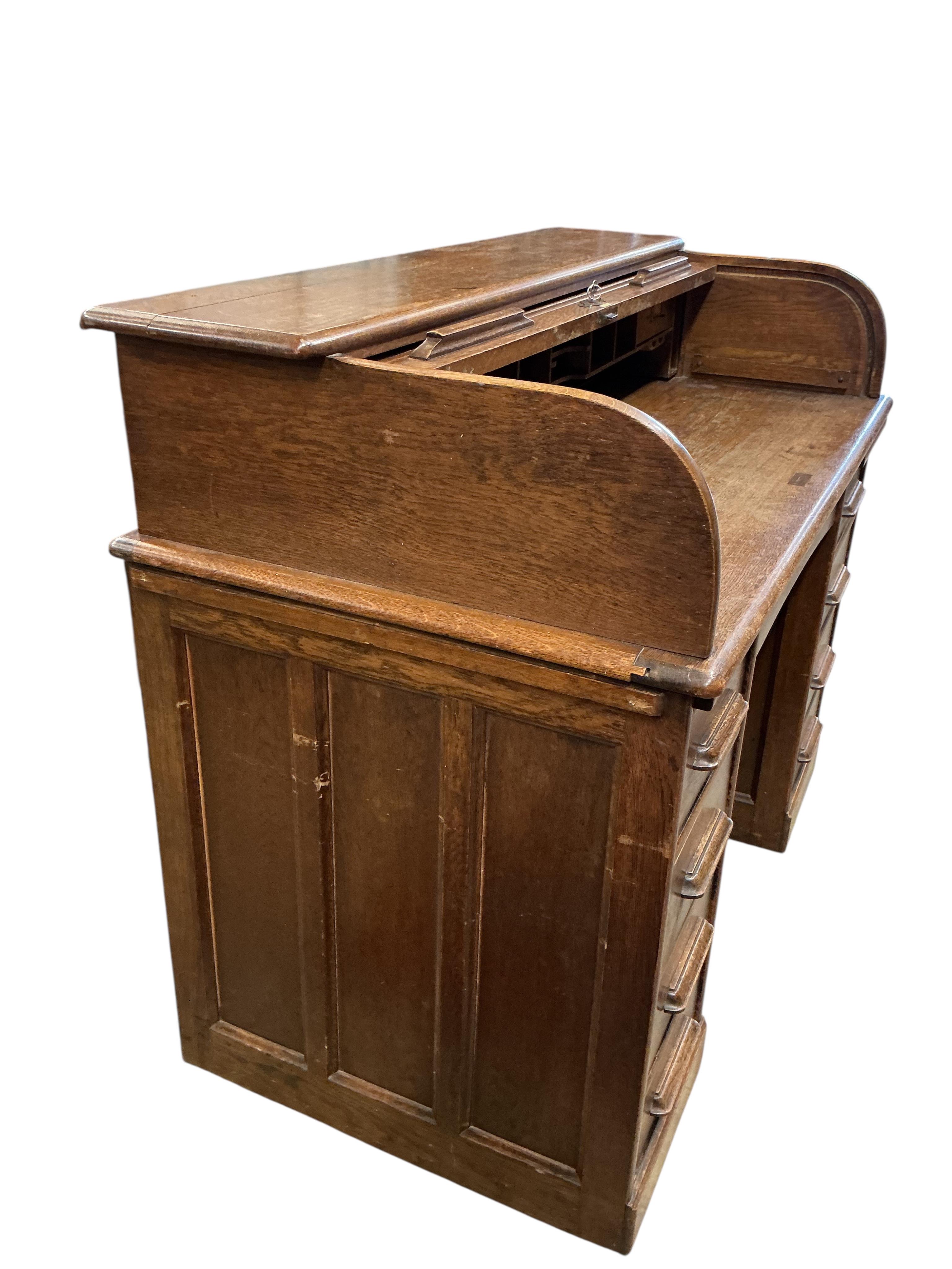 An early 20th century oak roll top desk, width 122cm, depth 66cm, height 101cm
